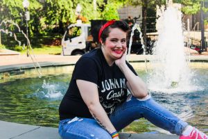 person sitting on the side of a fountain with a red headband